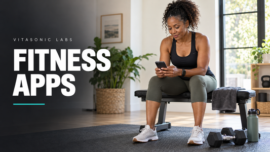 Vitasonic Labs Fitness Apps banner with an adult woman checking her phone beside home workout equipment.