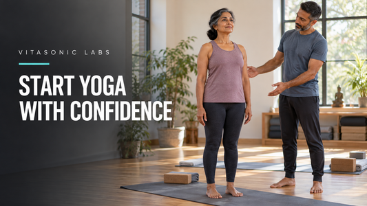 Vitasonic Labs beginner yoga banner with an adult woman standing on a mat beside an instructor in a bright studio.